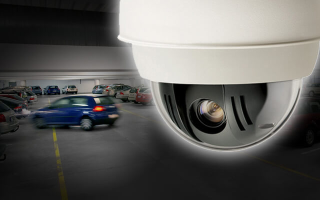 CCTV camera with built-in LED illuminators surveilling a car park